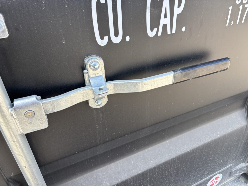 Close-up of easy-opening shipping container door locking bar and operating handle