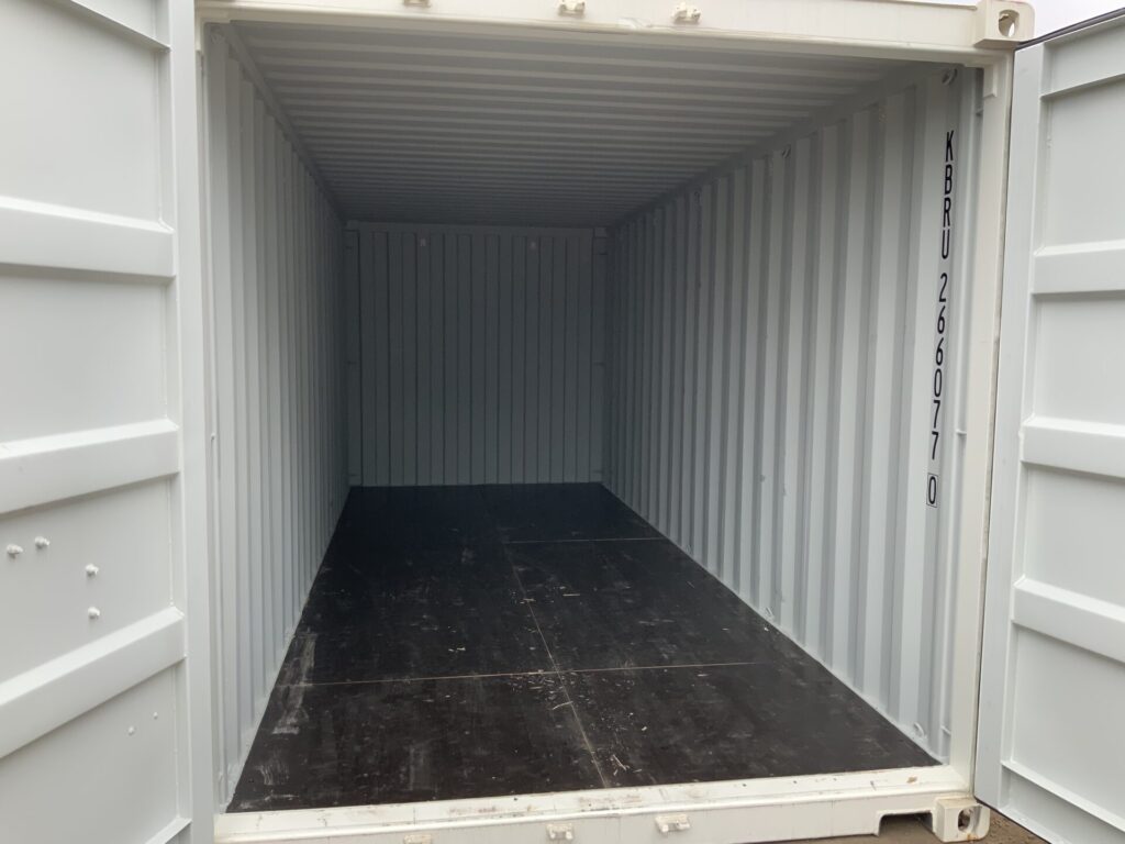 Immaculate interior of 20ft one-trip shipping container with premium 25mm black film-coated plywood floor and clean steel walls ready for secure storage.